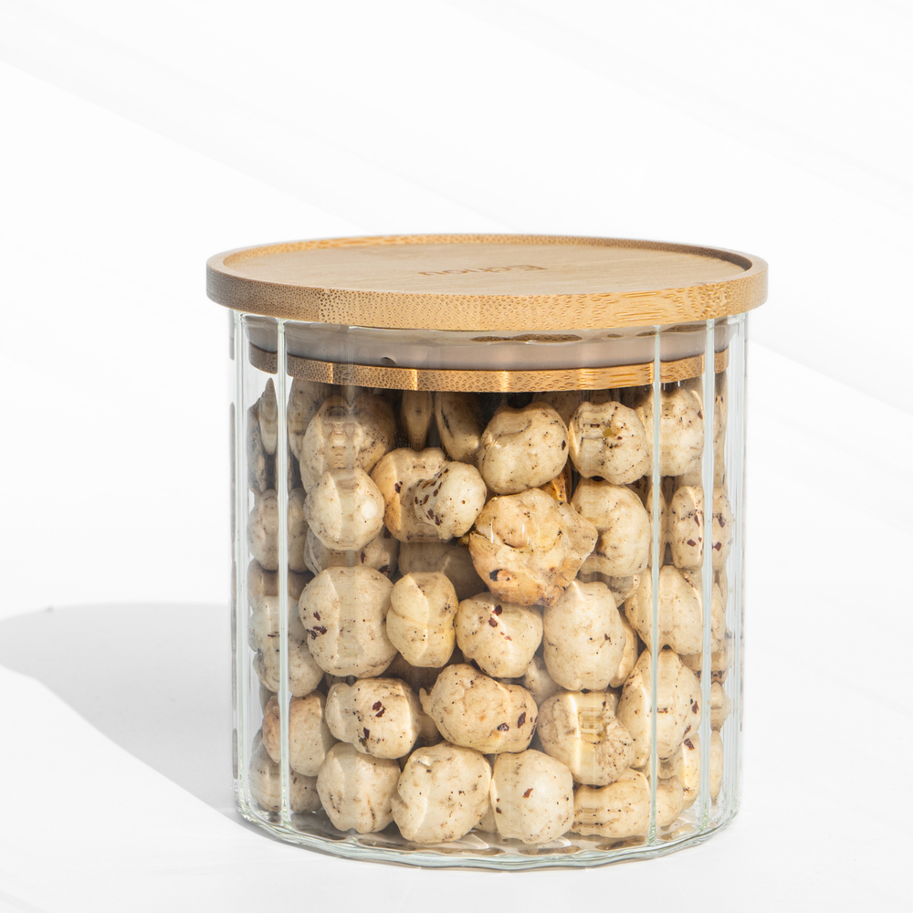 A fluted high borosilicate glass storage jar with a wooden lid, featuring a modern textured design and airtight sealing for stylish kitchen organization.