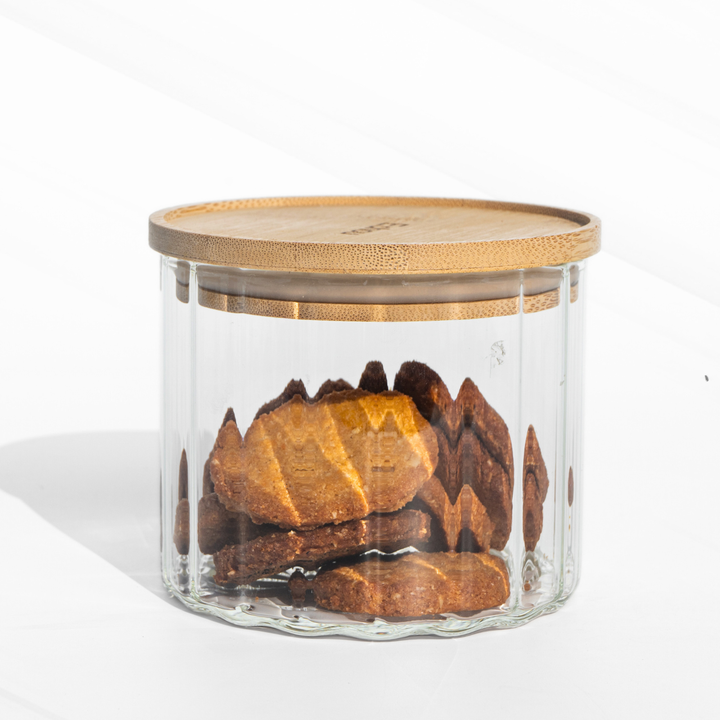 A fluted high borosilicate glass storage jar with a wooden lid, featuring a modern textured design and airtight sealing for stylish kitchen organization.