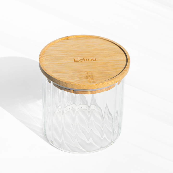 A fluted high borosilicate glass storage jar with a wooden lid, featuring a modern textured design and airtight sealing for stylish kitchen organization.